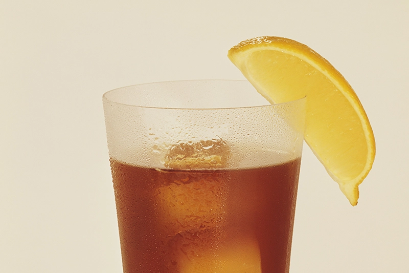 Ein Glas mit Eistee und einer Zitronenscheibe