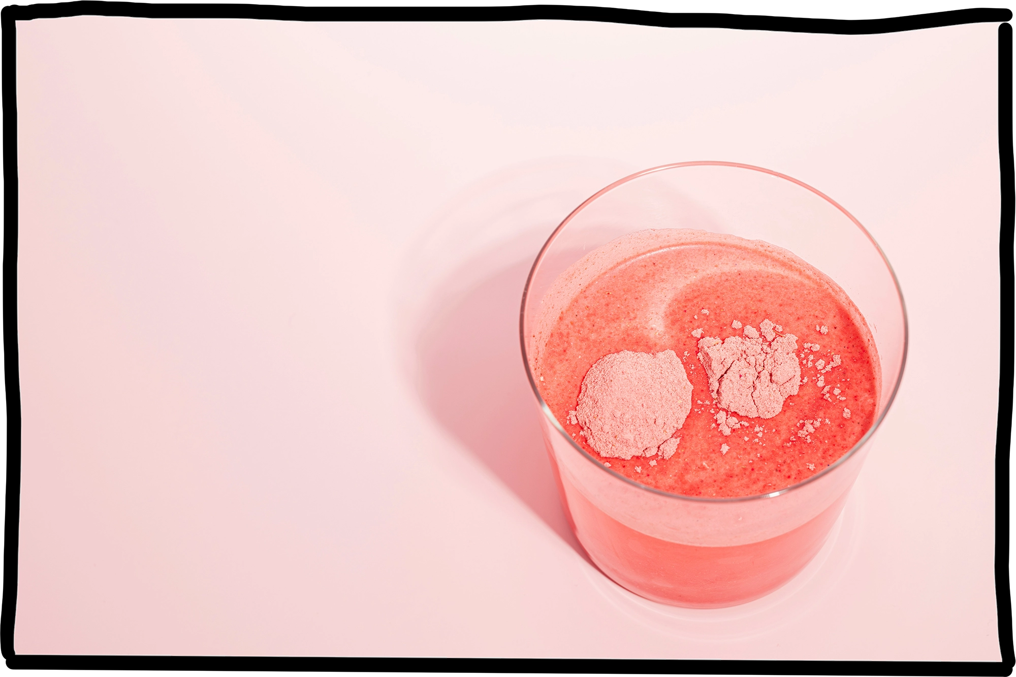 Ein Glas mit Wasser in dem ein pinkes Pulver hineingegeben wurde